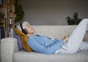 Older woman listening to music on couch